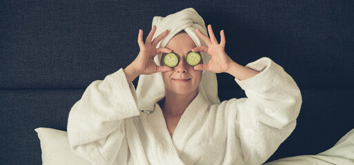 young woman getting eye nature treatment by cucumber at luxury spa resort. Wellness and healing...