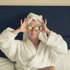 young woman getting eye nature treatment by cucumber at luxury spa resort. Wellness and healing...