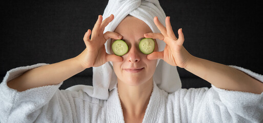 young woman getting eye nature treatment by cucumber at luxury spa resort. Wellness and healing...