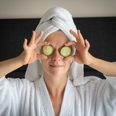 young woman getting eye nature treatment by cucumber at luxury spa resort. Wellness and healing...