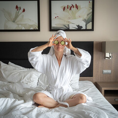 young woman getting eye nature treatment by cucumber at luxury spa resort. Wellness and healing...