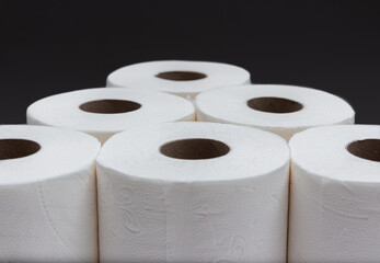 Toilet paper rolls in pyramid shape with black background. Version 2.