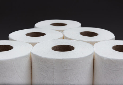 Toilet paper rolls in pyramid shape with black background. Version 2.