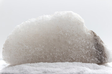 Mined rock salt laying on pile of iodized salt. Version IV.