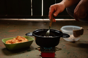 cocinando al aire libre. cocinando unas tortas fritas en una cocina portátil en el campo al aire...