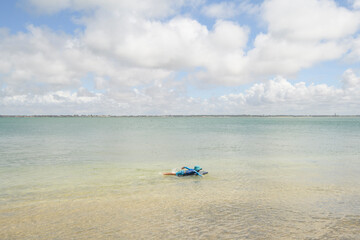jeune enfant qui nage avec un bodyboard en été sous un ciel bleu et une mer calme