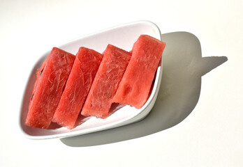 triangle slices of watermelon on white plate isolated on white background