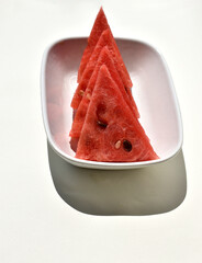 triangle slices of watermelon on white plate isolated on white background