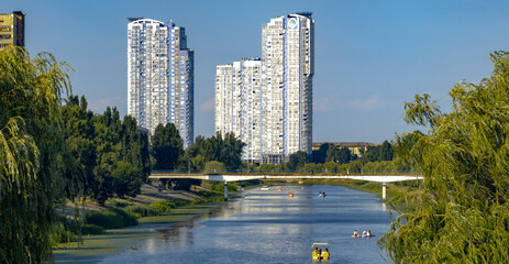 Tourists enjoying boat trip on Dnipro River with Kyiv skyscrapers in background