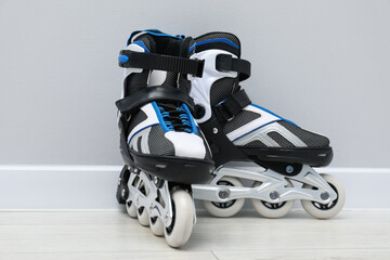 Pair of roller skates on floor near white wall