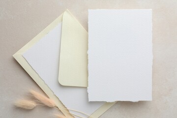 Wedding invitation cards, envelope and spikelets on color textured table, flat lay