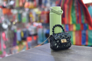 Miniature Handbag and Water Bottle on a Table