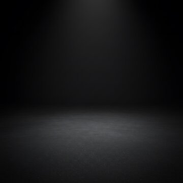 A dark, empty studio space with a concrete floor and black background.