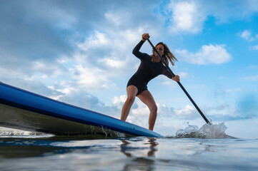 Solo woman racing on a paddleboard