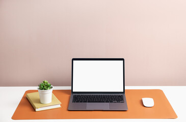 Fototapeta premium Stylish workplace with laptop and orange mousepad on white table indoors. Space for text