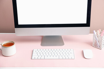 Fototapeta premium Stylish workplace with computer and pink mousepad on white table indoors, closeup. Space for text