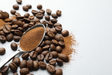 Spoon with instant coffee powder and beans on white background, closeup. Space for text