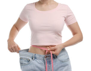 Woman with measuring tape wearing old jeans after weight loss on white background, closeup