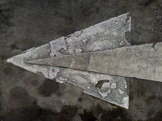 Weathered arrow painted on aged asphalt pavement showing wear, cracks and deterioration. Urban...