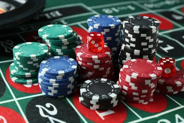 Casino chips and dice on roulette table, closeup