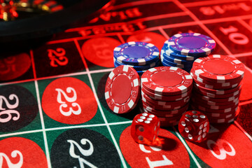 Casino chips and dice on roulette table, closeup