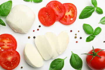 Tasty mozzarella cheese, tomatoes, basil and peppercorns on white background, flat lay