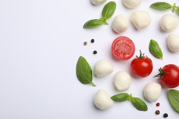 Tasty mozzarella cheese balls, tomatoes, basil and peppercorns on white background, flat lay. Space for text