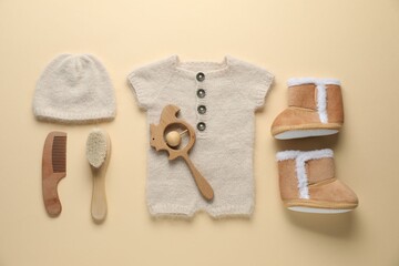 Baby clothes and accessories on beige background, flat lay