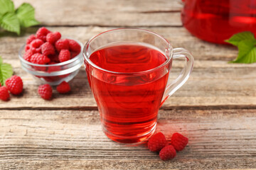 Tasty raspberry tea and berries on wooden table, closeup