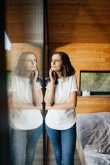 Woman relaxing and reflecting in modern wooden cabin