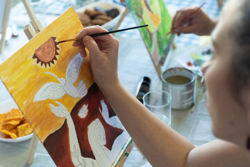 Closeup of a woman hand in an art workshop painting on canvas