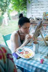 Woman artist painting in a summer art school workshop