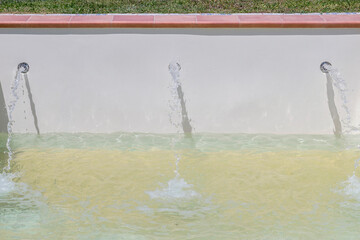 A reinforced concrete swimming pool is filled with water through three nozzles, at the beginning of...