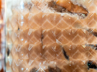 Square pattern on the surface of the clear glass that allows you to see the iced coffee inside