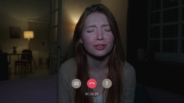 Medium shot with CGI video effects of carefree woman sitting in front of camera chatting on video call when power outage causes lamps to go dark and shadowy figure of intruder appears in hallway