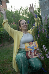 Creative female painting student in a summer painting school, proudly showing off her finished painting, an outdoor smiling portrait