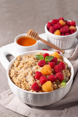 Delicious oatmeal porridge with raspberries and honey