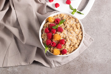 Delicious oatmeal porridge with raspberries and honey