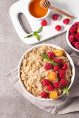 Delicious oatmeal porridge with raspberries and honey