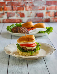 hamburger sliders made with ground beef, lettuce, tomato, and onion
