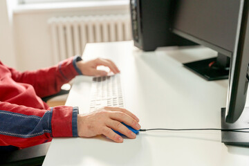 Person working at a desk with a computer in a well-lit office environment during daytime hours