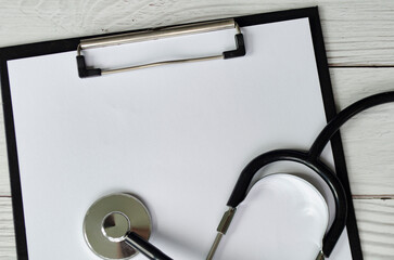 Medical form on clipboard with pen and stethoscope with customizable space for text or message.