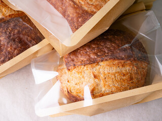 Sourdough Bread Loaf in Transparent Plastic Bag on White Background – Ready for Sale or Delivery