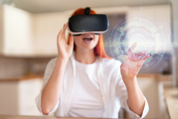 Engaging virtual reality experience in a modern kitchen as a woman explores digital worlds with VR...