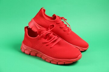 Pair of red sneakers on green background
