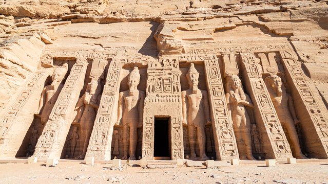 The facade and entrance gate of the temple of Hator and queen Nefertari, in the archeological site of Abu Simbel, Egypt. With symbols, hieroglypics and big statues.