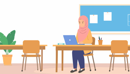 Muslim woman in a pink hijab and yellow shirt working on a laptop at a wooden desk.