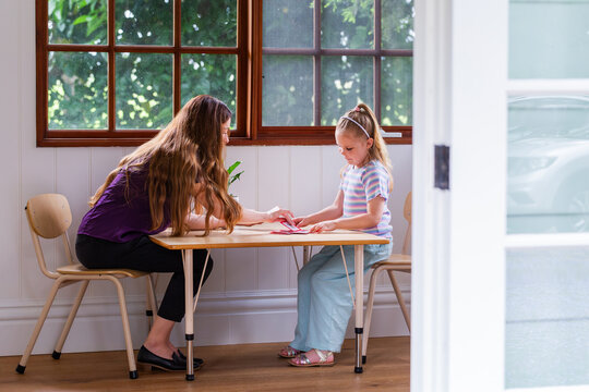 Speech pathologist working with young girl using word flash cards for language development