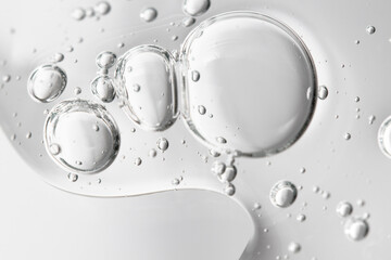 Hyaluronic acid, lotion and tonic bubbles flow down the transparent surface, macro.