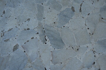 Natural stone texture with irregular slate-like pieces, cracks, and organic patterns. Ideal background for architectural surfaces, design materials, and 3D texturing.